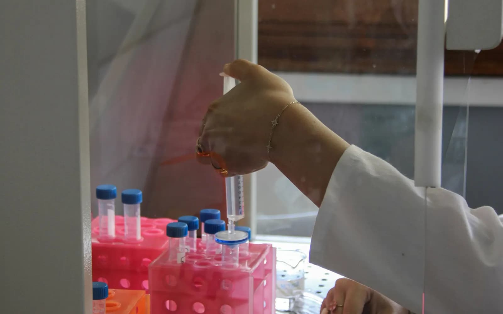Scientifique manipulant des échantillons colorés dans un laboratoire.