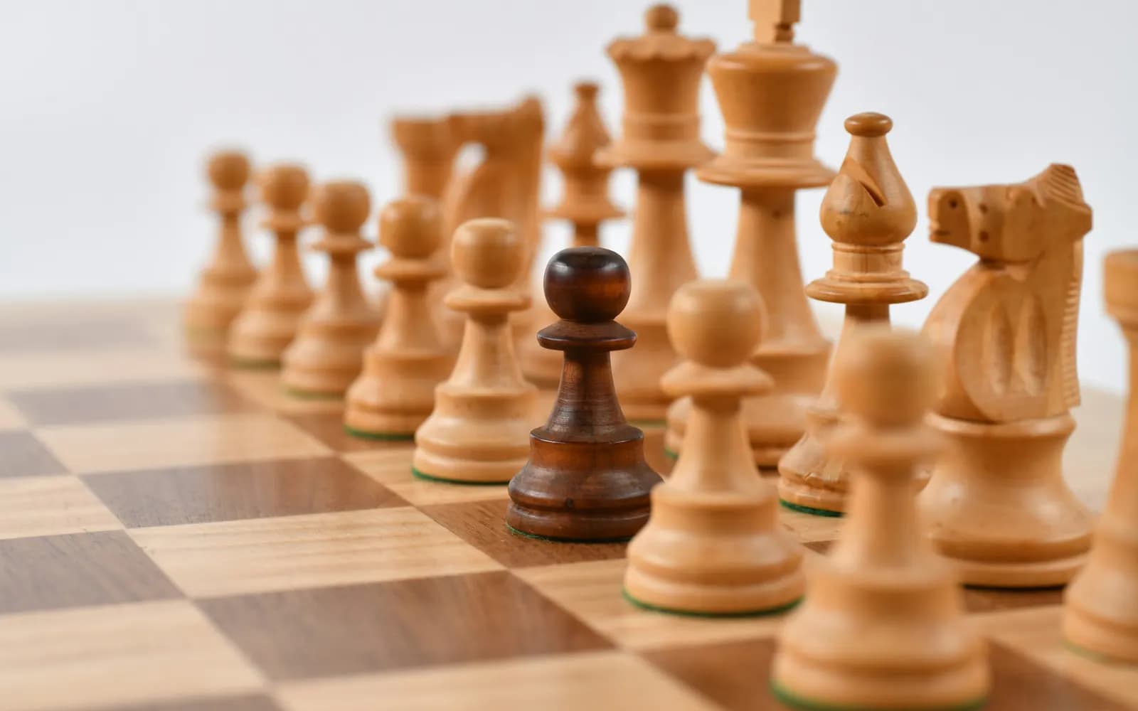 Pièces d'échecs disposées sur un échiquier autour d'une pièce distincte.